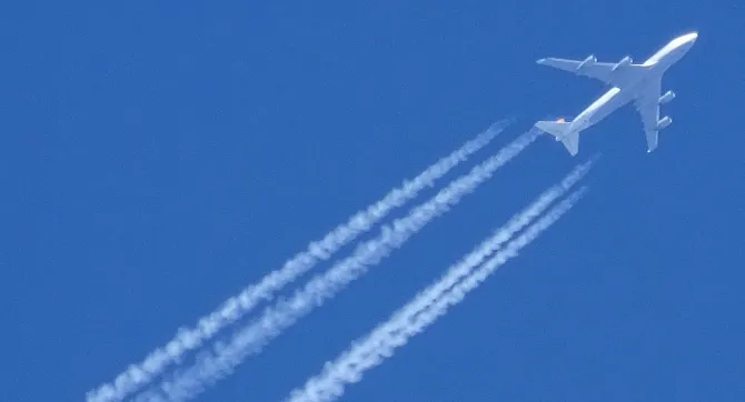 vliegtuig met contrails hoog in de lucht