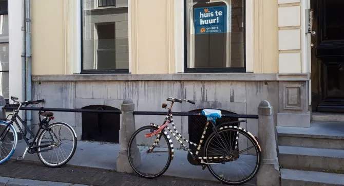 Twee fietsen voor een huis. 