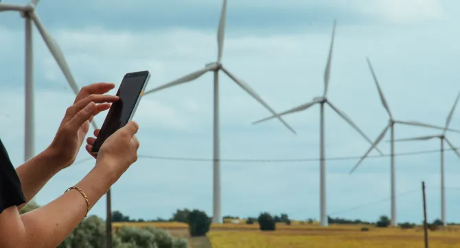 Mobiele telefoon tegen de achtergrond van een windmolenpark