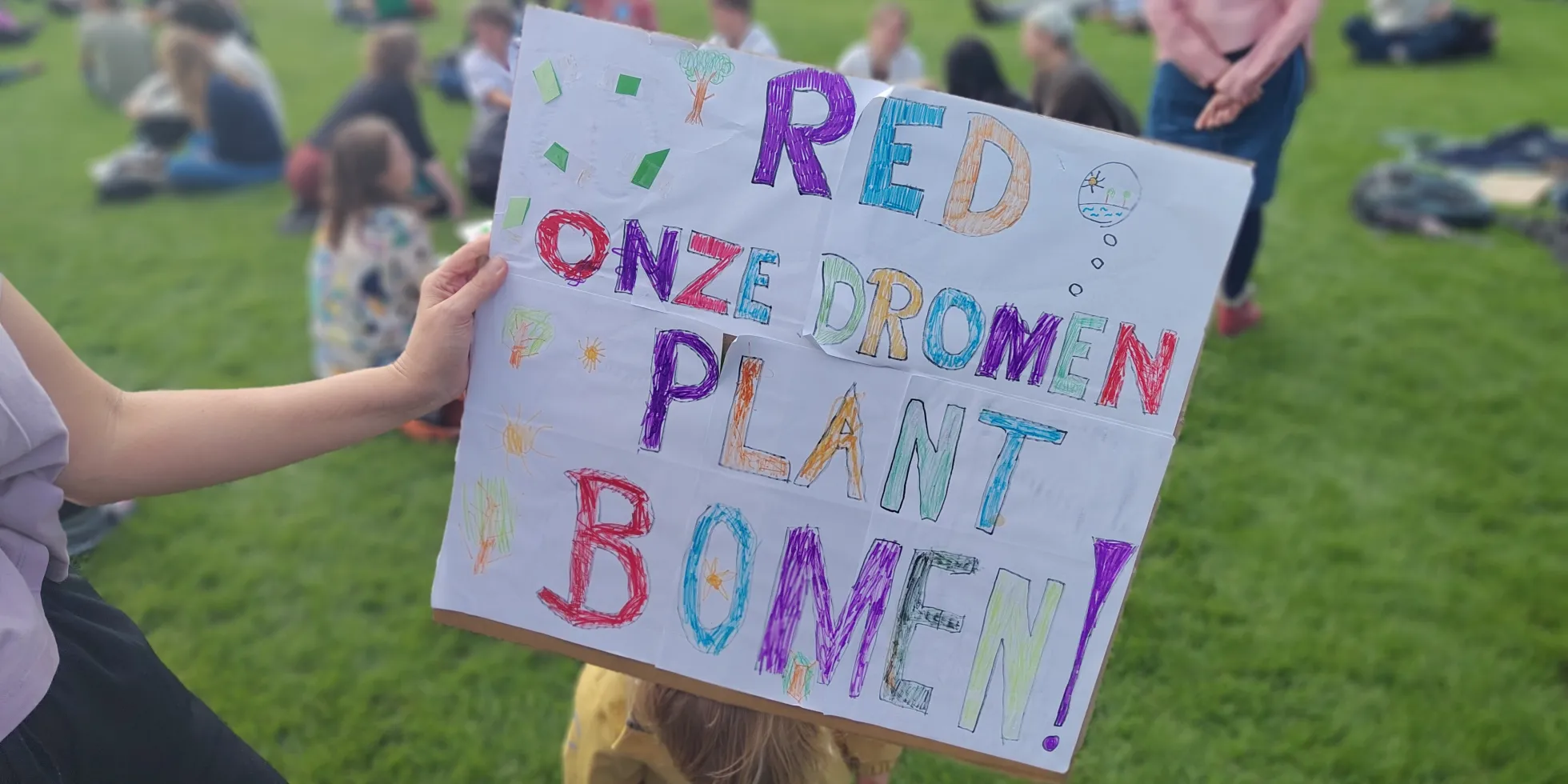 bord van kind bij klimaatprotest met tekst 'Red onze dromen, plant bomen'