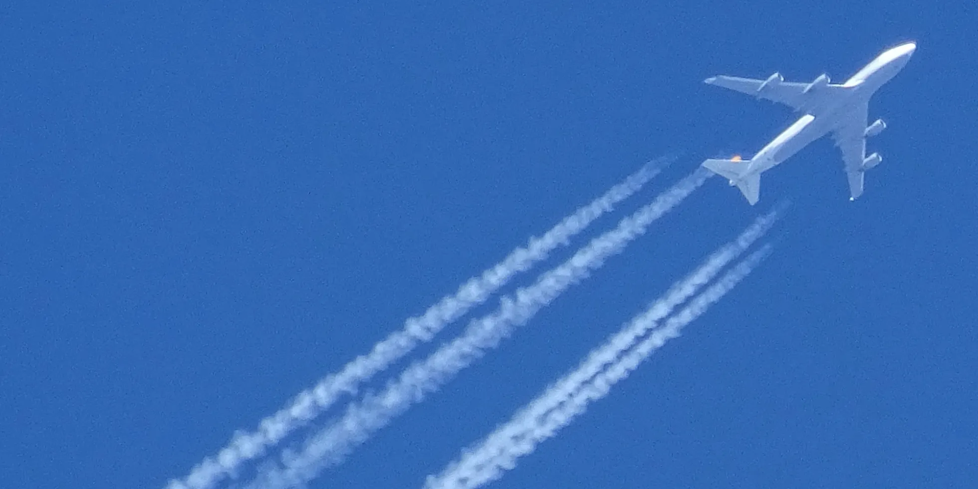 vliegtuig met contrails hoog in de lucht